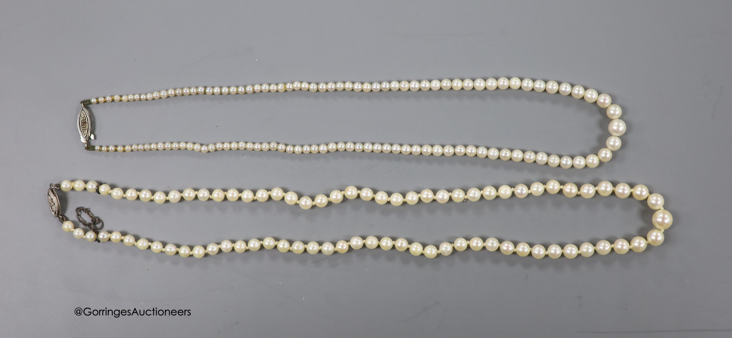 Two single strand graduated cultured pearl necklaces, one with 14k white metal clasp,45cm, the other with 9ct white metal clasp, 40cm.